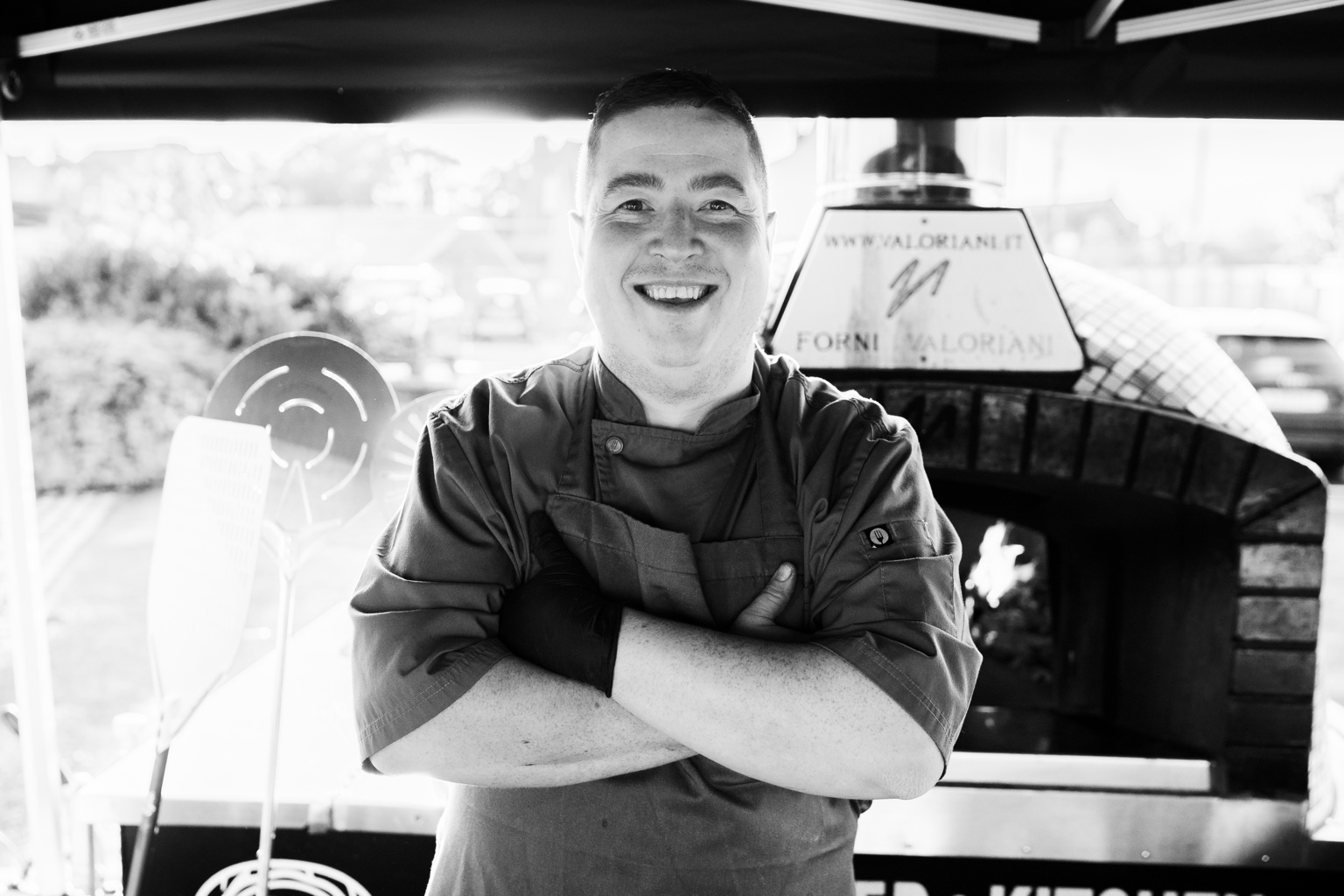Chef and owner Chris Glenn beside a pizza oven