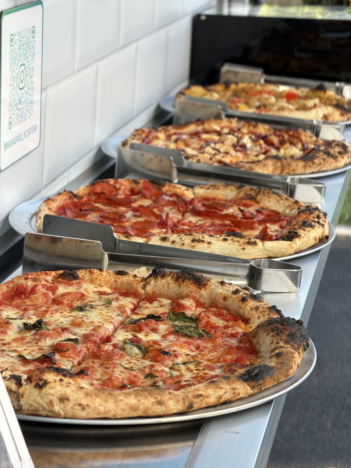 Fresh pizzas laid out for guests at a catered event