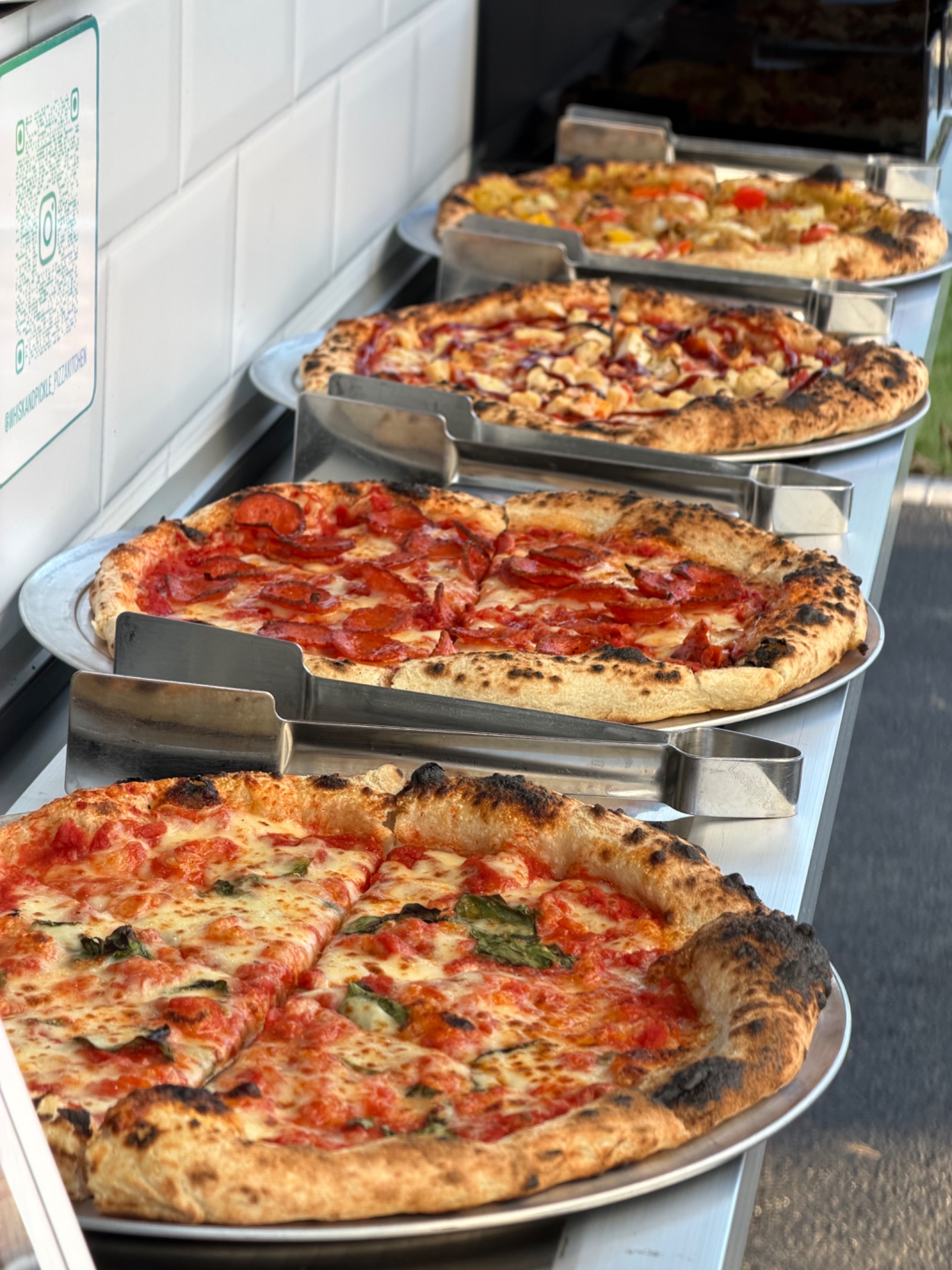 Freshly baked Whisk And Pickle pizzas ready to serve